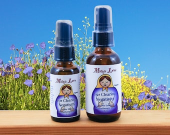 May include: Two amber glass bottles with spray tops, labelled "Mama Love" and "For Clearing Negativity" with a cartoon illustration of a woman. The smaller bottle is 1 oz and the larger bottle is 2 oz.