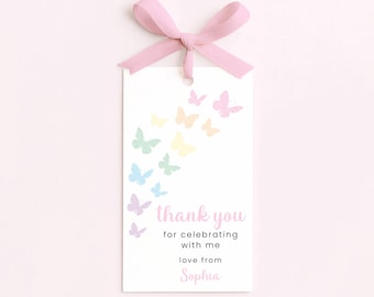 May include: A white gift tag with pastel butterfly illustrations and a pink ribbon. The tag reads "thank you for celebrating with me love from Sophia". The butterflies are in shades of pink, yellow, green, and blue.