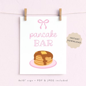 Könnte beinhalten: Ein weißes Schild mit den Worten "pancake BAR" in rosa Schrift und einem Stapel Pfannkuchen mit Sirup und Butter. Das Schild wird von zwei Holzklammern gehalten. Die Worte "INSTANT DOWNLOAD" stehen auf einem beigen Aufkleber.
