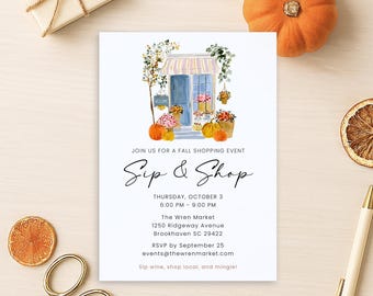 May include: A white invitation with the text "Sip & Shop" and event details. The invitation features a watercolour illustration of a shop with pumpkins and flowers. Other items include a gift box, scissors, a pen, and a dried orange slice.