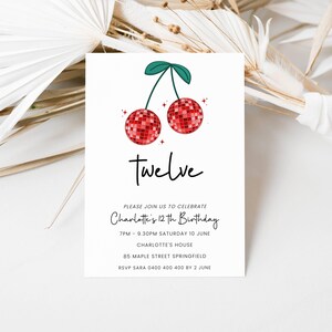 May include: A white invitation card with a red and green cherry design. The text on the card reads "Twelve" and "Please join us to celebrate Charlotte's 12th Birthday". The invitation includes the date, time, location, and RSVP information.