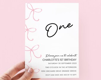 May include: A white invitation card featuring pink bow illustrations and the word "One" in black script. The card's text reads "Please join us to celebrate CHARLOTTE'S 1ST BIRTHDAY Saturday 30 September 2023".