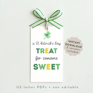 Op de afbeelding: Een wit cadeaulabel met een groen en witte strik. Het label heeft de tekst "a St Patrick's Day TREAT for someone SWEET" in groen en geel. Een klavertje vier staat bovenaan.