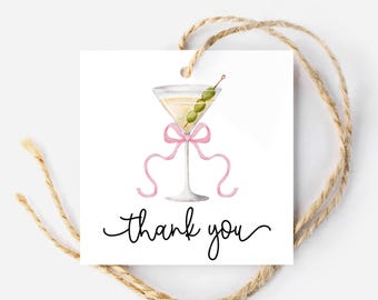 Può includere: Un'etichetta di ringraziamento quadrata bianca con un'illustrazione ad acquerello di un bicchiere da martini con un'oliva verde e un nastro rosa. Il testo "grazie" è scritto in corsivo nero.
