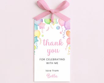May include: A rectangular white gift tag featuring a pastel watercolour illustration of balloons and stars. The text reads thank you FOR CELEBRATING WITH ME love from Bella. A light pink ribbon is tied through a hole at the top of the tag.