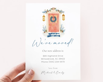 May include: A white card with the text "We've moved!" in a handwritten font. The card features a watercolor illustration of a pink door decorated with a wreath and winter foliage. The new address and contact information are also included.