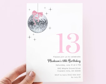May include: A white invitation card with a pink disco ball and the number 13. The text reads "Madison's 13th Birthday" and includes the date, time, and location. A pink bow is attached to the disco ball.