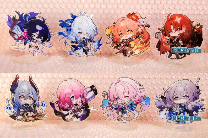 May include: Set of ten anime character acrylic stands. The characters are all female and have colourful hair and outfits. The stands are clear and have a white background. The text "ACGcrafts" appears on two of the stands.