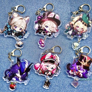 May include: Six colorful anime character keychains with gold rings. Each keychain features a different character with a unique design and a sparkly background.