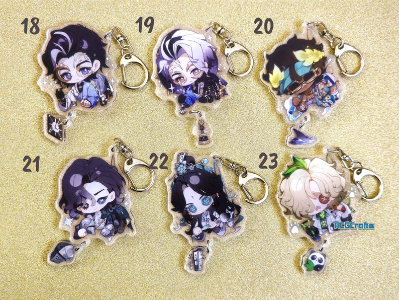 May include: Six colorful anime character keychains with glitter accents. Each keychain features a different character with unique details and a silver metal ring.