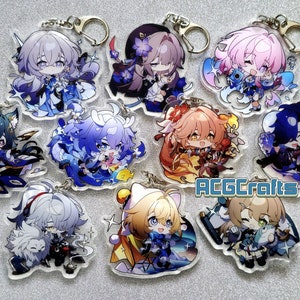 Op de afbeelding: Een set van negen anime-personage sleutelhangers met verschillende personages met verschillende haarkleuren en outfits. De sleutelhangers zijn gemaakt van helder acryl en hebben een glanzende afwerking. De personages zijn allemaal in chibi-stijl, met grote hoofden en kleine lichamen. De sleutelhangers zijn allemaal bevestigd aan zilveren sleutelringen.