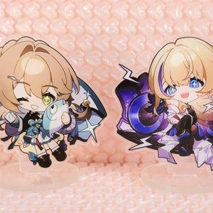 May include: Four anime-style character stickers with colourful designs. The characters are depicted in a chibi style with large eyes and bright colours. The stickers are printed on clear vinyl and have a glossy finish.