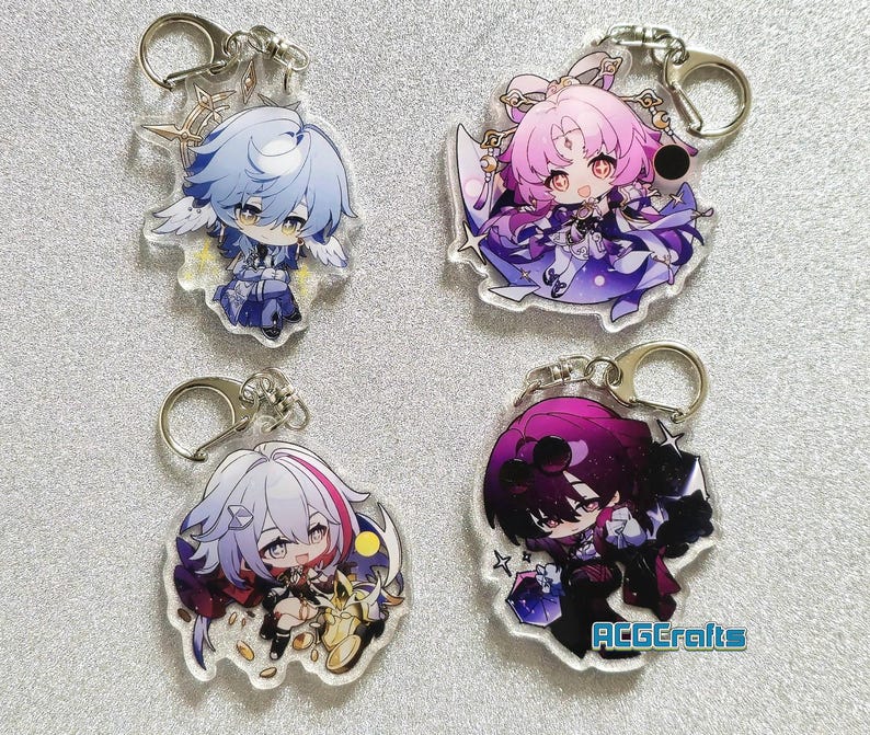 Op de afbeelding: Vier kleurrijke anime-personage sleutelhangers met zilveren sleutelringen. Elke sleutelhanger heeft een ander personage met een uniek ontwerp en levendige kleuren.