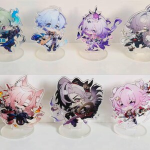 May include: Set of 8 acrylic character stands featuring anime characters with various hairstyles and outfits. The stands are clear and have a circular base.