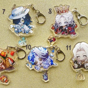 May include: Ten colorful anime character keychains with clear plastic backgrounds. Each keychain features a different character with unique details and accessories. The keychains are attached to silver key rings.