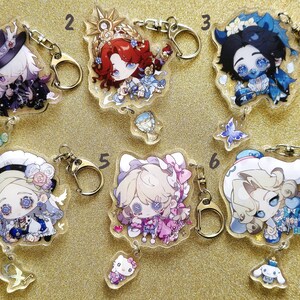 May include: Ten colorful acrylic keychains featuring anime-style characters with different expressions and poses. Each keychain has a metal ring and a clear background with glitter accents.