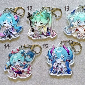 May include: Set of ten colorful anime character keychains with different designs. Each keychain features a different character with blue hair and a unique outfit. The keychains are made of clear acrylic and have a metal ring for attaching to keys or bags.