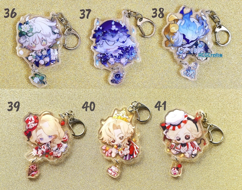 May include: Six clear acrylic keychains with different anime characters. Each keychain has a silver metal ring and a charm dangling from the bottom. The charms are different designs, including a cake, a flower, and a heart.