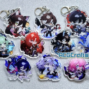 Op de afbeelding: Een set van tien kleurrijke anime-personage sleutelhangers met verschillende ontwerpen. Elke sleutelhanger heeft een ander personage met unieke details en accessoires. De sleutelhangers zijn gemaakt van helder acryl en hebben een zilveren metalen ring om aan sleutels of tassen te bevestigen.