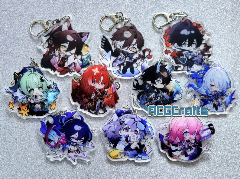 Op de afbeelding: Een set van tien kleurrijke anime-personage sleutelhangers met verschillende ontwerpen. Elke sleutelhanger heeft een ander personage met unieke details en accessoires. De sleutelhangers zijn gemaakt van helder acryl en hebben een zilveren metalen ring om aan sleutels of tassen te bevestigen.