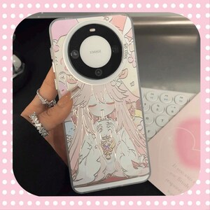 Może przedstawiać: Przezroczyste etui na telefon z r&oacute;żowo-białą ilustracją w stylu anime. Etui posiada duży obiektyw aparatu oraz tekst "XIMAGE" i "SO COOL". Projekt zawiera postać trzymającą nap&oacute;j.