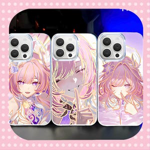 Peut inclure: Trois coques de téléphone avec des illustrations de style anime. Chaque coque présente une image différente d'un personnage aux cheveux roses et aux yeux violets. Les coques ont une bordure transparente et une finition brillante.