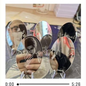 Puede incluir: Cinco exhibidores ovalados de acrílico espejado con retratos y nombres grabados. Cada exhibidor se sostiene con un soporte de plástico transparente. Los retratos son de personas con cabello oscuro. Los nombres están escritos en cursiva.