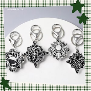 May include: Four silver keychains with intricate, geometric designs. Each keychain features a different shape, including a starburst, a square with a crescent, and a stylized emblem. The keychains are attached to silver clasps. The text "BECAUSR OF YOU" is visible.