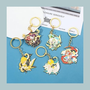 Puede incluir: Cinco llaveros metálicos coloridos con anillos y cadenas doradas. Cada llavero presenta un diseño de personaje de estilo anime diferente con detalles intrincados y colores vibrantes. Los llaveros se muestran sobre un fondo azul claro.