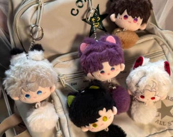 May include: A collection of plush keychains featuring cartoon-style characters with fluffy hair and animal ears. The keychains are in various colors, including white, black, purple, and brown, with matching pom-pom tails. Each keychain has a silver metal ring.