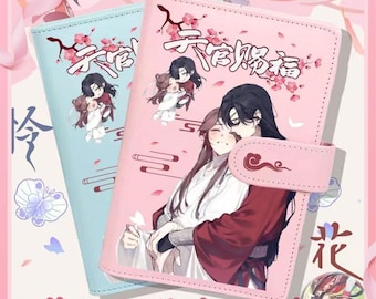 May include: Two decorative phone cases, one light blue and one pink, featuring illustrations of anime characters and Chinese characters. The pink case has a clasp. The cases are decorated with floral and butterfly motifs.