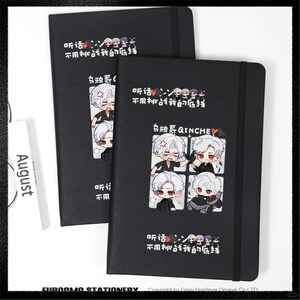 Puede incluir: Dos cuadernos negros con un diseño de dibujos animados que presenta un personaje con cabello blanco y el texto "QINCHE". Los cuadernos tienen un cierre de banda elástica negra y el texto "August" en una tarjeta blanca.