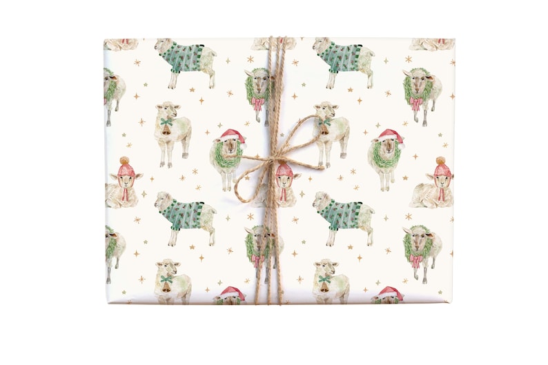May include: Wrapped gift with a festive sheep pattern. The design features watercolour illustrations of sheep wearing sweaters, Santa hats, and wreaths, with gold stars on a cream background. Tied with twine.
