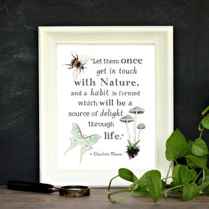 May include: A white framed print with a quote about nature. The quote reads "Let them once get in touch with Nature, and a habit is formed which will be a source of delight through life." - Charlotte Mason. The print features illustrations of a bumblebee, a moth, and mushrooms.