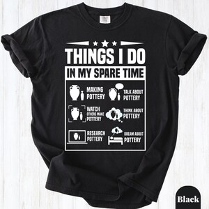 May include: A black short-sleeved t-shirt featuring white text and graphics. The design reads THINGS I DO IN MY SPARE TIME followed by six icons and labels: MAKING POTTERY, TALK ABOUT POTTERY, WATCH OTHERS MAKE POTTERY, THINK ABOUT POTTERY, RESEARCH POTTERY, and DREAM ABOUT POTTERY.