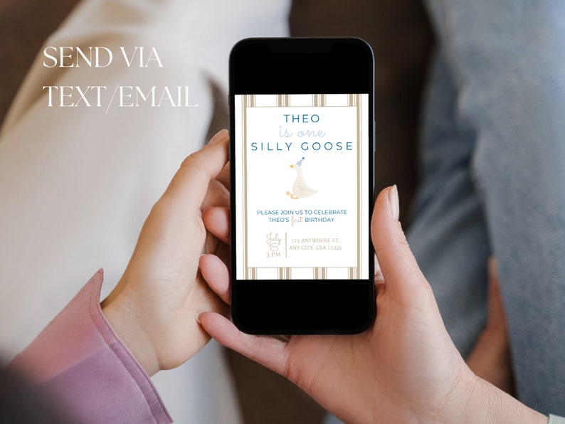 May include: A digital invitation on a smartphone screen for a first birthday party. The invitation features a cartoon goose wearing a party hat and the text "Theo is one Silly Goose". The invitation includes the date, time, and location of the party.