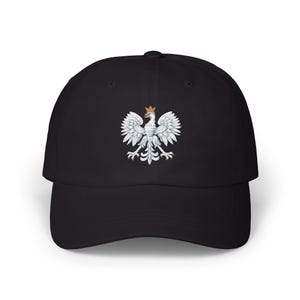 Puede incluir: Gorra de béisbol negra con el emblema del Águila Blanca polaca. El emblema es blanco con una corona dorada. La gorra tiene una visera curva y un diseño clásico ajustable.