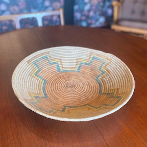 Vintage round coiled woven basket: made of natural materials, coral and turquoise accent colors, Southwestern