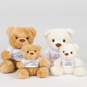 Puede incluir: Tres osos de peluche de diferentes tamaños. El oso más grande es marrón y tiene una camiseta blanca con el texto "To our Grand Theod Love Grandma & Co.". El oso del medio es marrón y tiene una camiseta blanca con el texto "To our Son Charlir Love Mommy & Daddy". El oso más pequeño es blanco y tiene una camiseta blanca con el texto "To our Daughter Florence Love Mommy & Daddy".
