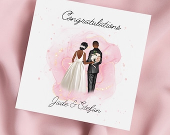 Op de afbeelding: Een trouwkaart met een roze aquarel achtergrond en gouden accenten. De kaart toont een zwart stel in trouwkledij, waarbij de bruid een boeket bloemen vasthoudt. De tekst "Congratulations Jade & Stefan" is op de kaart gedrukt.