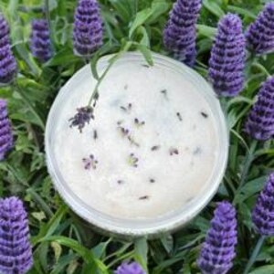 Peut inclure: Un bol blanc rempli d'une substance cr&eacute;meuse, peut-&ecirc;tre un pi&egrave;ge &agrave; insectes fait maison, avec de petits insectes pi&eacute;g&eacute;s &agrave; l'int&eacute;rieur. Le bol est entour&eacute; de fleurs violettes et d'herbe verte.