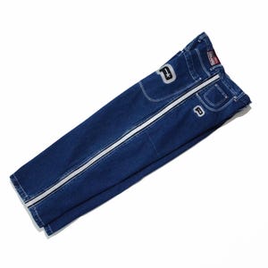 May include: Dark blue denim jeans with a white stripe down the side of each leg. The jeans have a white star and a white letter "D" on the pockets. The brand name is visible on the back.