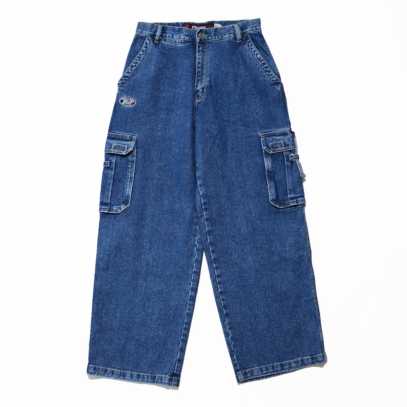 May include: Blue denim cargo pants with multiple pockets and a relaxed fit. The pants feature a logo patch near the front pocket and a classic five-pocket design. The denim has a medium wash and a straight leg.