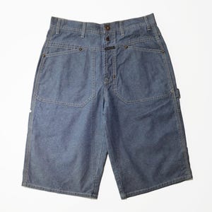 May include: Blue denim shorts with large front pockets and a button closure. The shorts have a classic workwear style with reinforced stitching and a relaxed fit. The shorts are approximately 20 inches long.