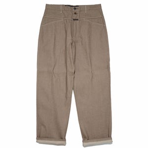 May include: High-waisted, tan-coloured trousers with a button closure and front pockets. The relaxed-fit trousers are cuffed at the ankles. The lighter-coloured stitching provides a contrast.