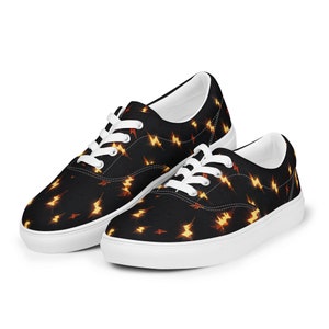 May include: A pair of black canvas low-top sneakers with white laces and a white sole. The sneakers have a pattern of yellow lightning bolts on a black background.