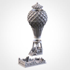 May include: A grey, 3D-printed decorative urn with a lattice design, a separate pedestal, and a small fence-like base. The urn has a lid and a woven basket-like texture. The pedestal has a small staircase. The objects are displayed against a white background.