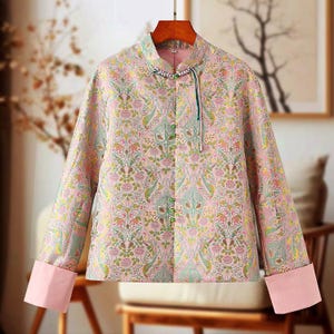 May include: A pink and green patterned jacket with a mandarin collar and long sleeves. The jacket has a button closure and a decorative tassel.