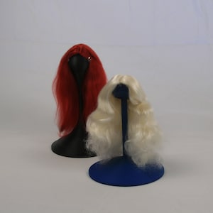May include: Two wigs on display stands. The wig on the left is red and the wig on the right is blonde.