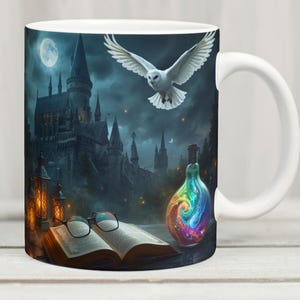 Puede incluir: Taza de cerámica blanca con una ilustración de fantasía. El diseño incluye un castillo, un búho volando y una botella de poción con remolinos de arcoíris. Un libro abierto y gafas están en primer plano. La taza tiene un asa blanca.